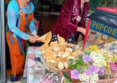 Des bénévoles font des popcorn pendant la Kermesse de La KafeTière 2024