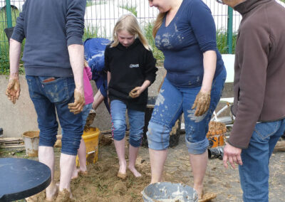 Des gens preparent la terre pour le four à papier, lors du weekend de l'artisanat a Pleumeur-Bodou